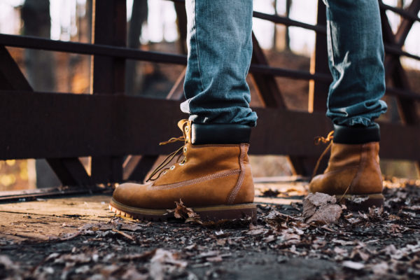 Man,Wearing,Boots,Standing,On,Bridge